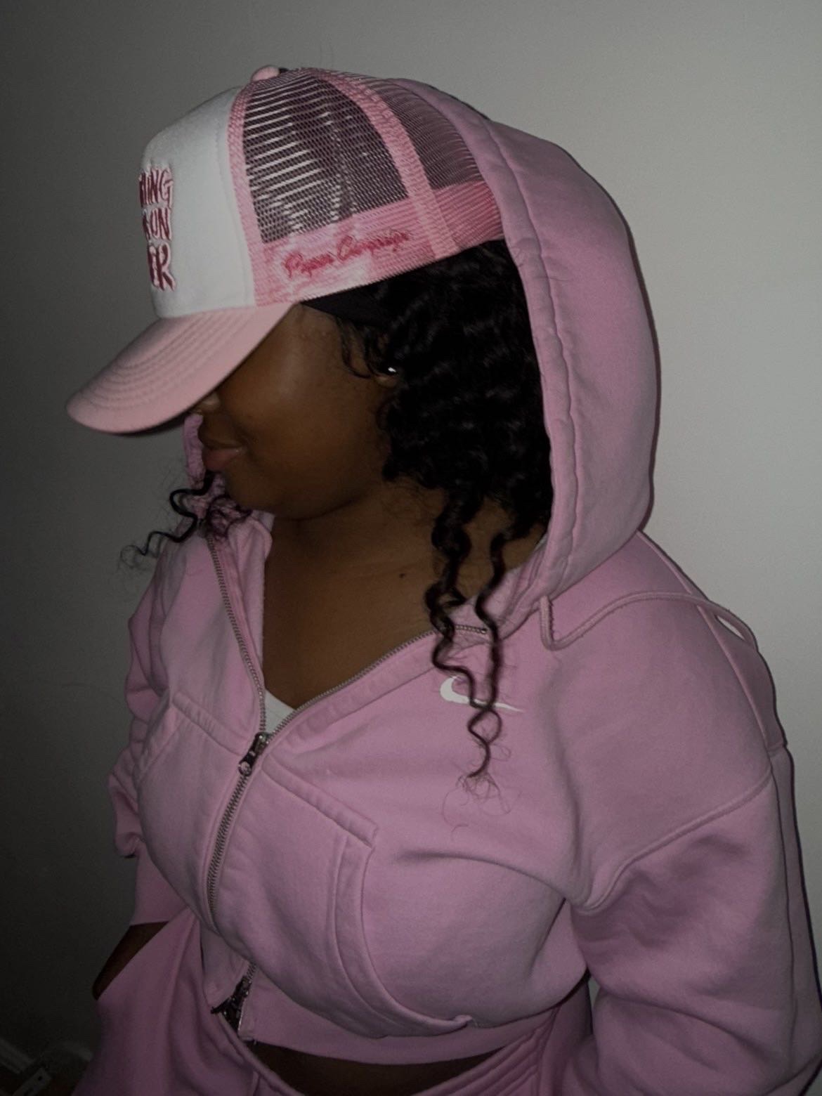 Model wearing a pink and white Paper Campaign trucker cap with a pink hooded top